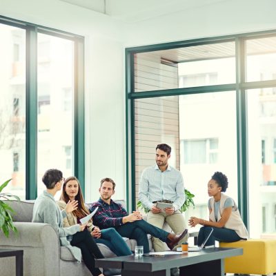 Business people, modern office and brainstorming with planning, social impact and ideas for project. Diversity, share input and group with feedback and production review with synergy or creative team.